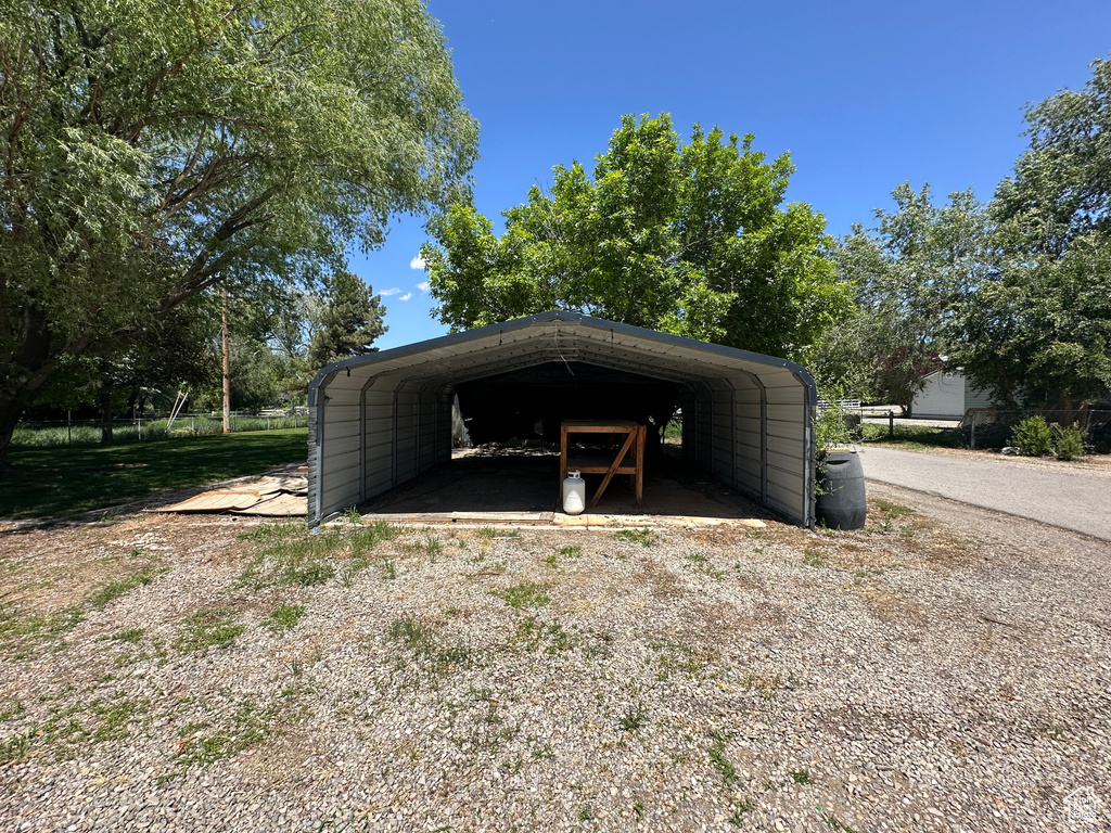 View of parking / parking lot featuring a carport