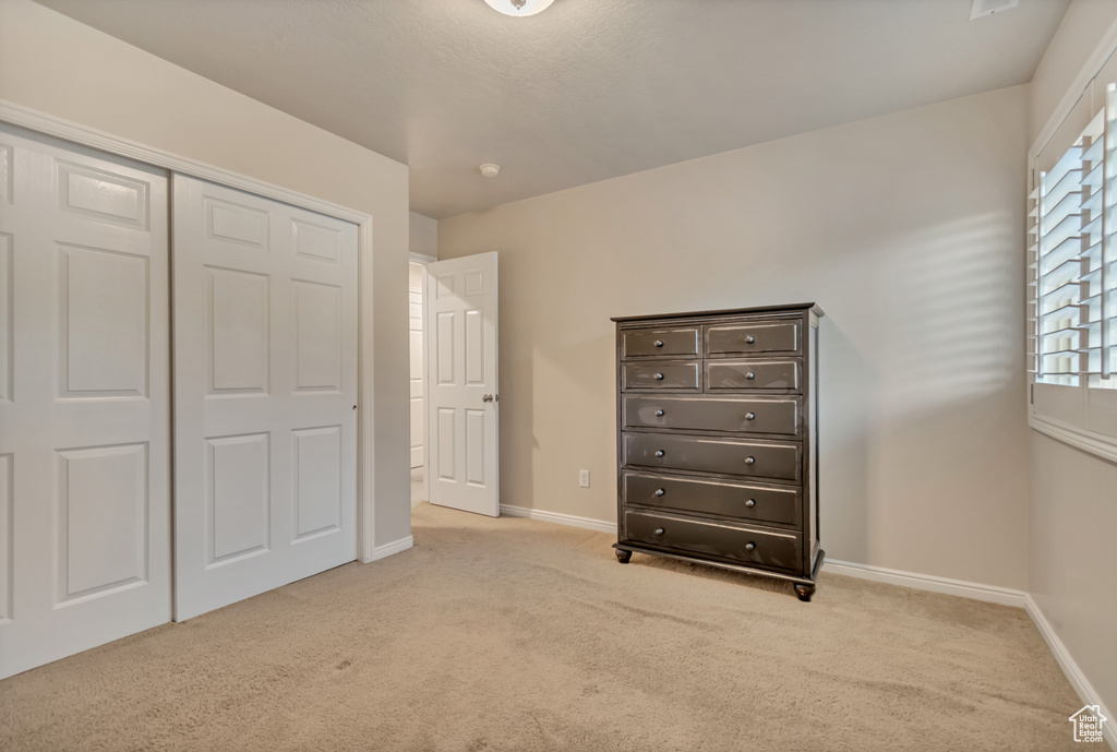 Unfurnished bedroom featuring carpet, baseboards, and a closet