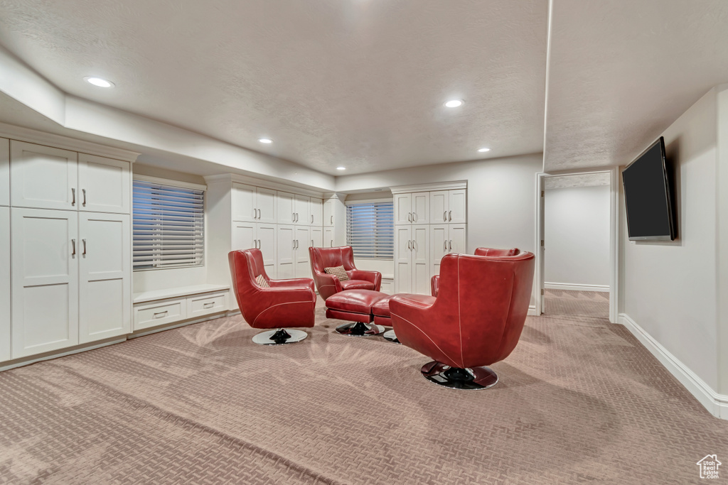 Living area featuring light carpet, baseboards, and recessed lighting