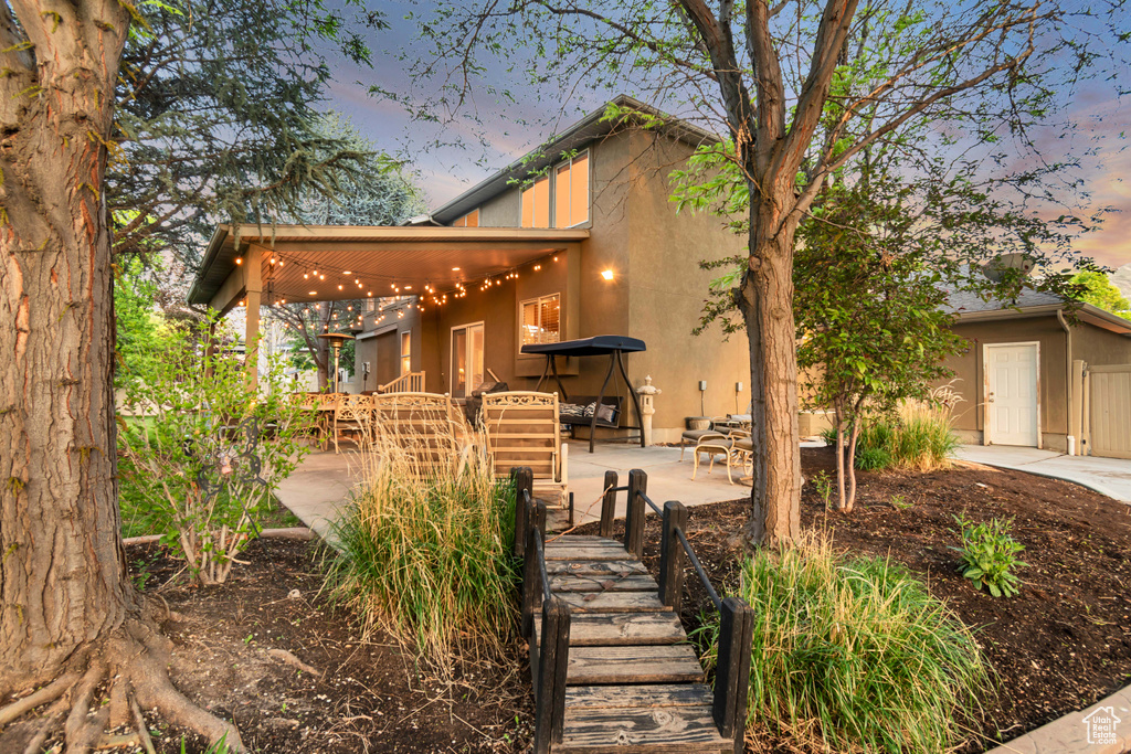 View of front of property with a patio area and stucco siding