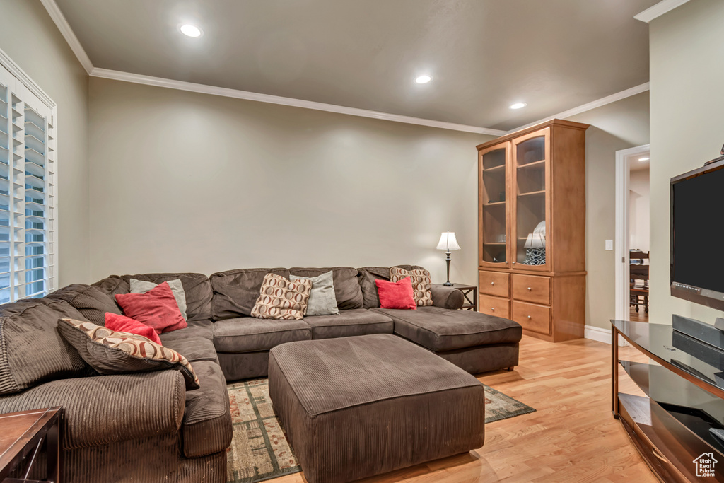 Living area featuring light wood-style flooring, ornamental molding, recessed lighting, and baseboards