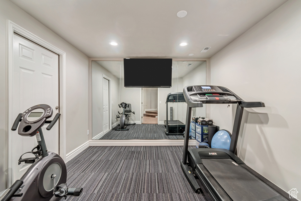 Exercise room with dark carpet, recessed lighting, and baseboards