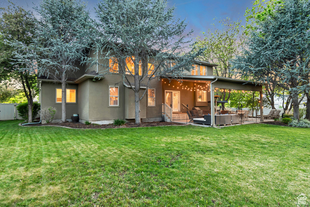 Rear view of property with an outdoor hangout area, a patio, and stucco siding