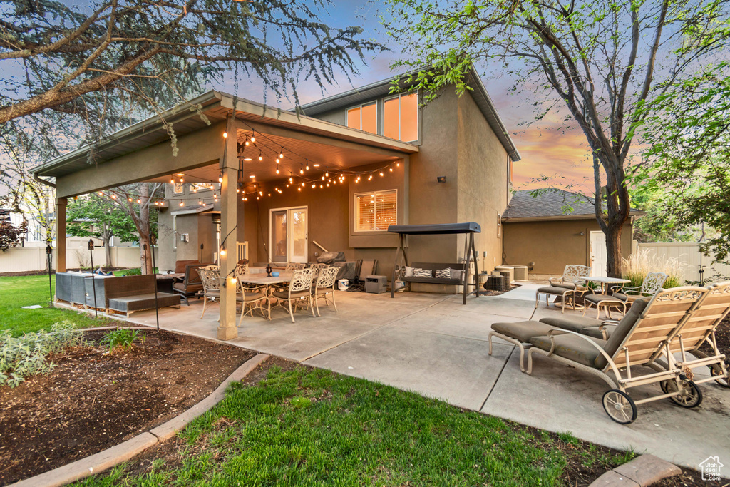 Rear view of property with stucco siding, outdoor lounge area, a patio, fence, and outdoor dining space