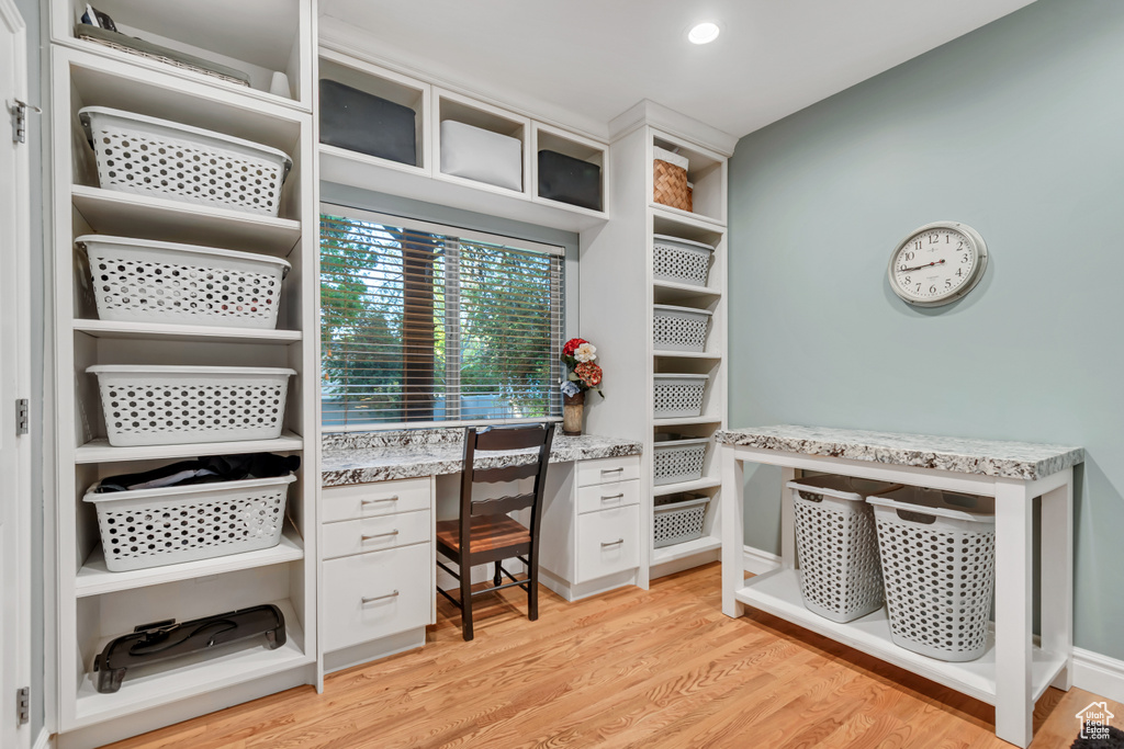 Walk in closet featuring light wood finished floors and built in study area