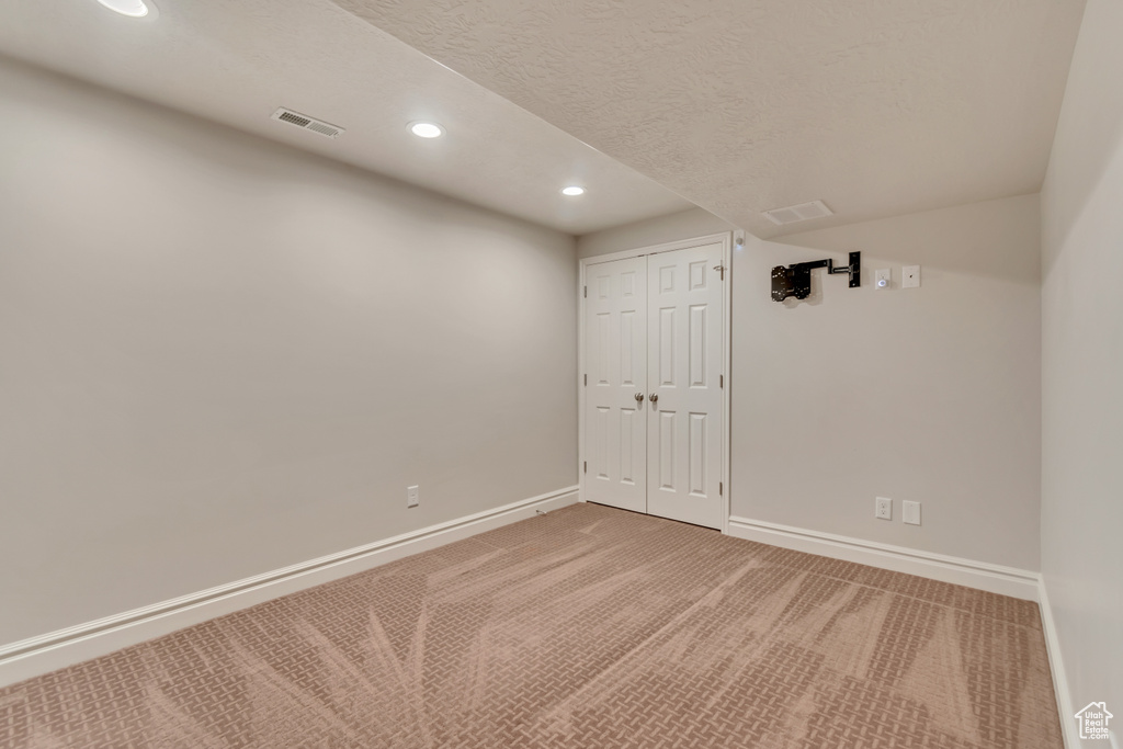 Finished basement featuring recessed lighting, carpet flooring, baseboards, and a textured ceiling