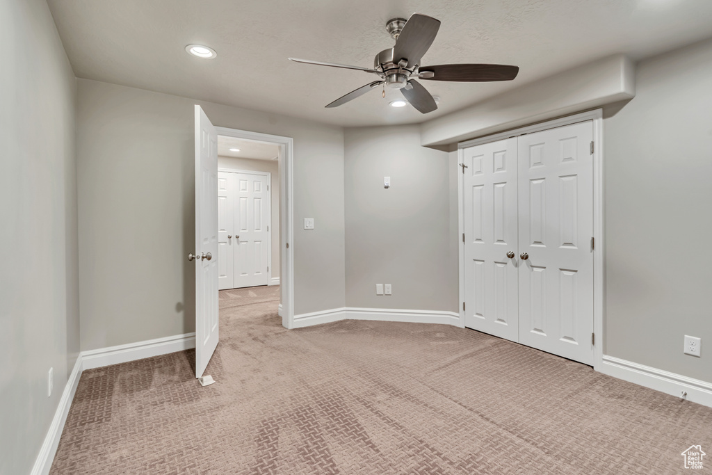 Carpeted empty room featuring ceiling fan, recessed lighting, and baseboards