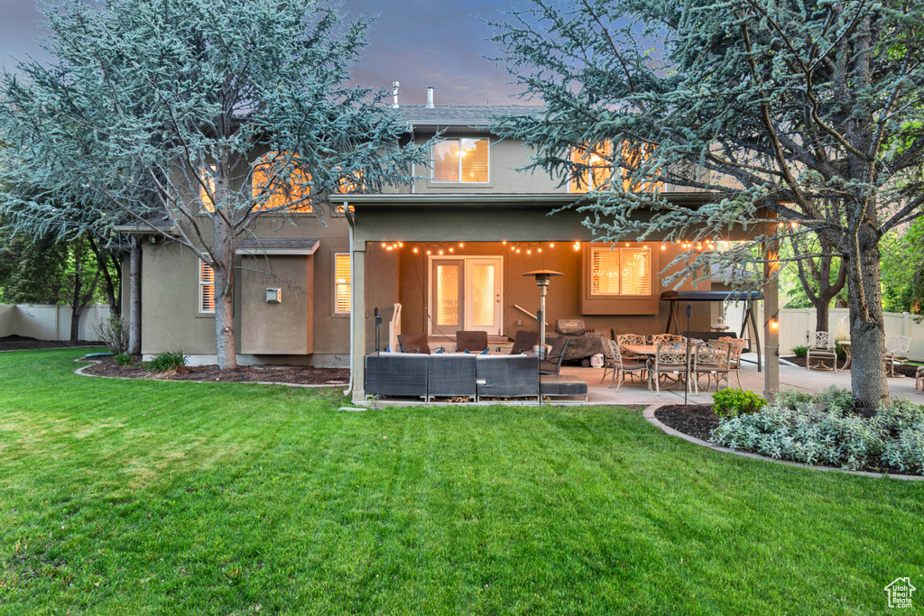 Back of property with stucco siding, a patio, and an outdoor hangout area