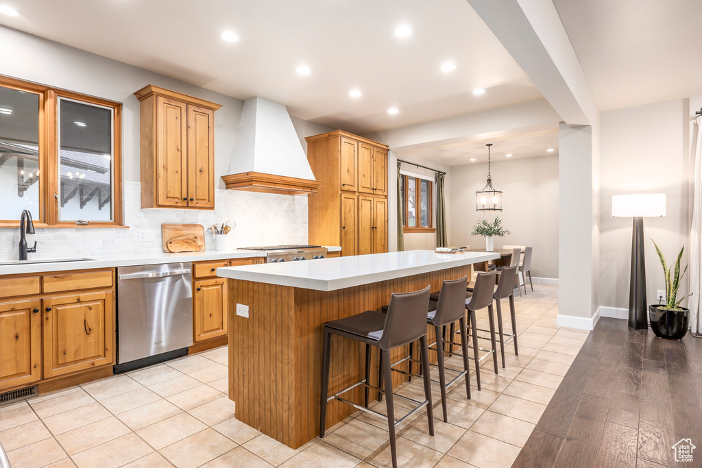 Kitchen with dishwasher, a sink, wall chimney range hood, recessed lighting, and decorative backsplash
