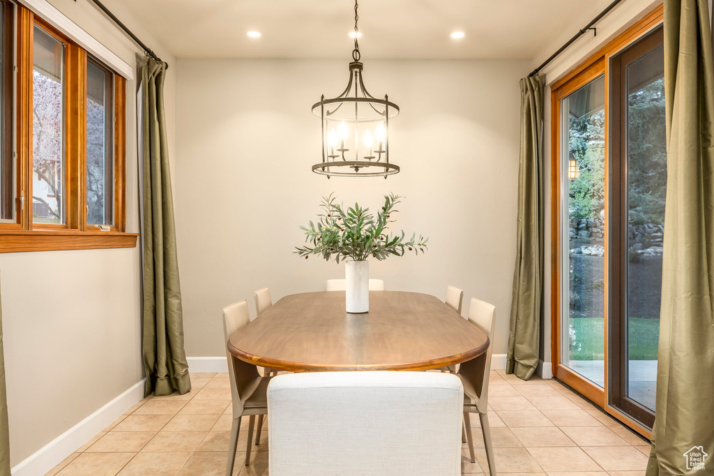 Dining space with light tile patterned floors, recessed lighting, baseboards, and a chandelier