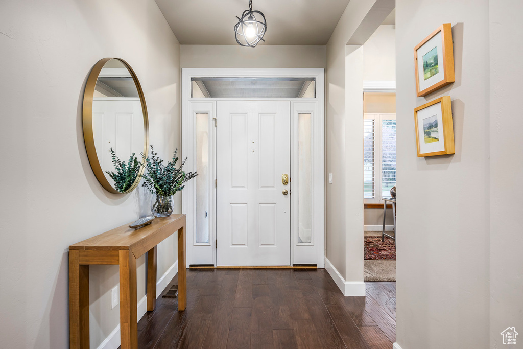Entrance foyer with dark wood-type flooring and baseboards