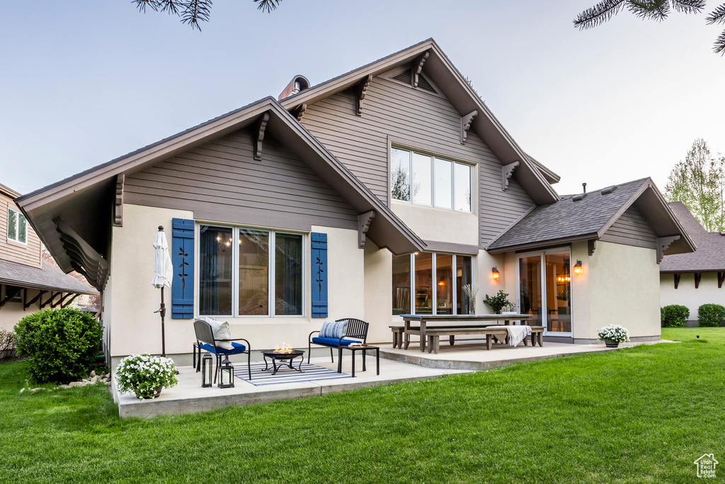 Rear view of house featuring an outdoor fire pit, a patio area, a yard, stucco siding, and roof with shingles