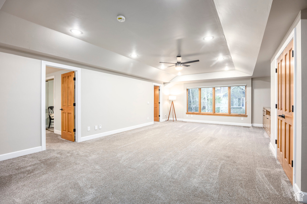 Unfurnished living room with ceiling fan, carpet floors, baseboards, recessed lighting, and lofted ceiling