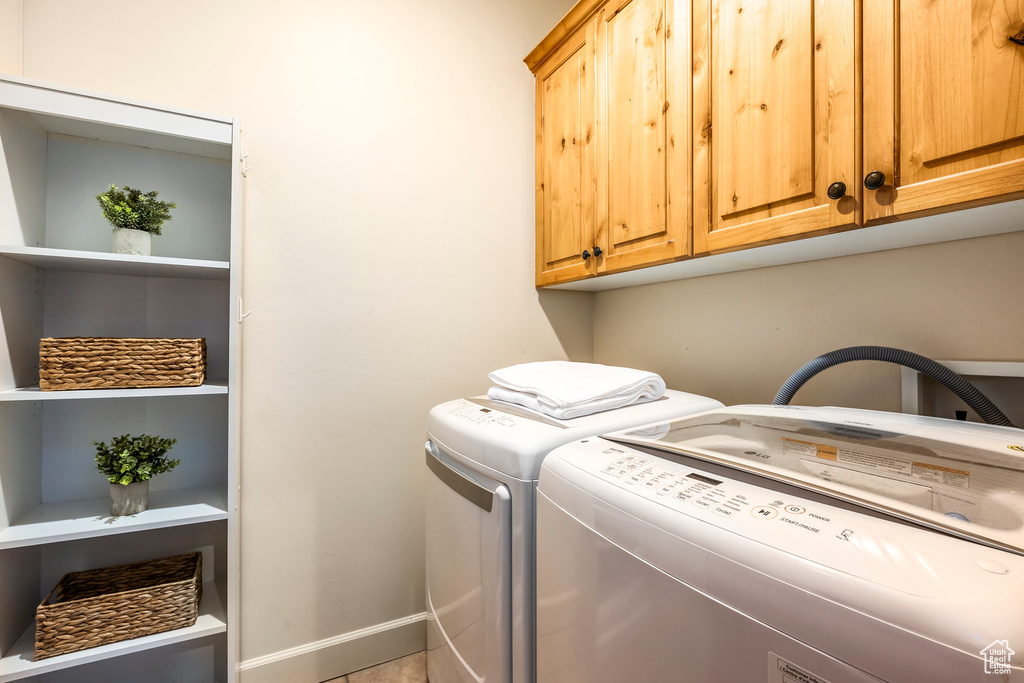Laundry room featuring cabinet space, washer and dryer, and baseboards