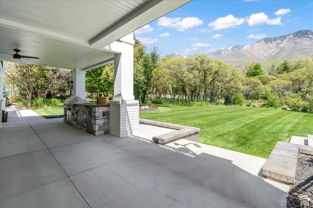 View of patio featuring area for grilling, a ceiling fan, a mountain view, and grilling area