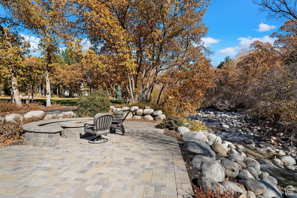 View of patio / terrace featuring a fire pit and view of scattered trees