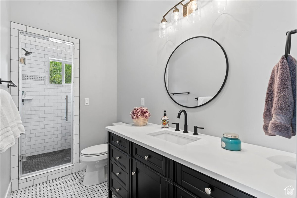 Full bath featuring a stall shower, toilet, and vanity