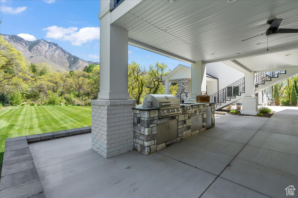 View of patio / terrace featuring area for grilling, stairway, a sink, a mountain view, and a grill
