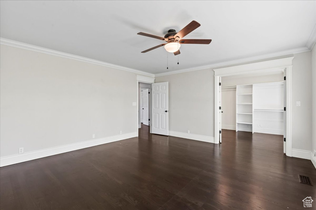 Unfurnished room with ceiling fan, baseboards, ornamental molding, and dark wood finished floors