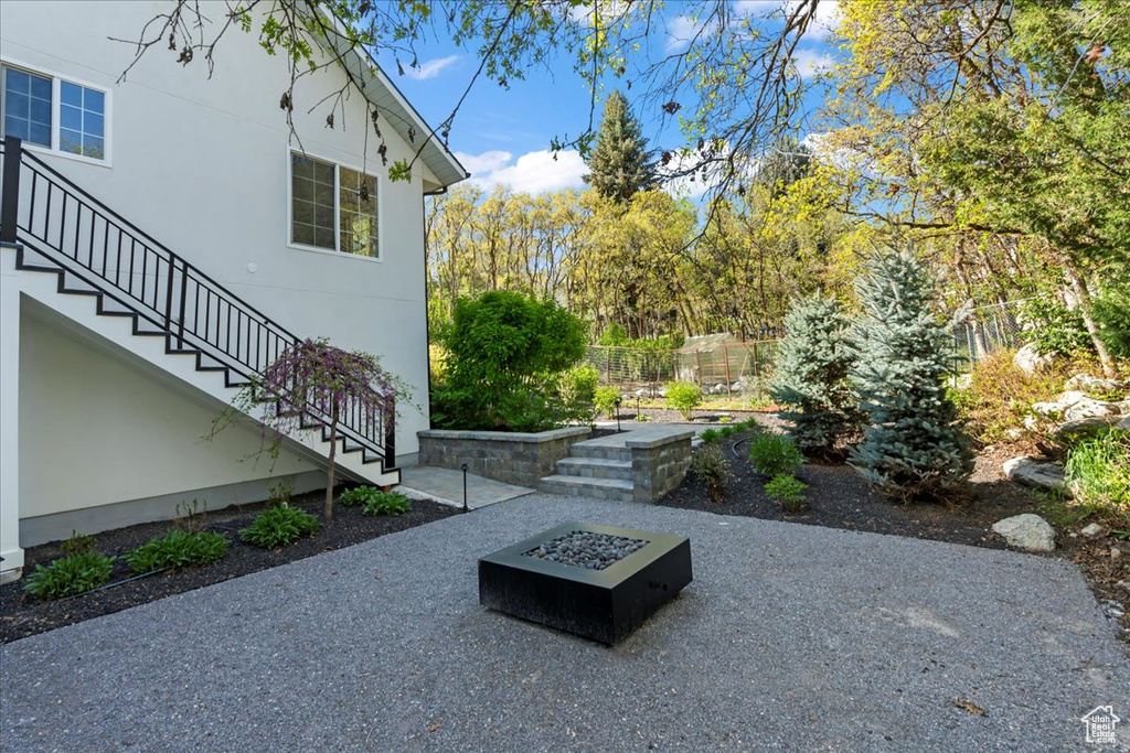 View of yard with stairs, fence, a patio, and a fire pit