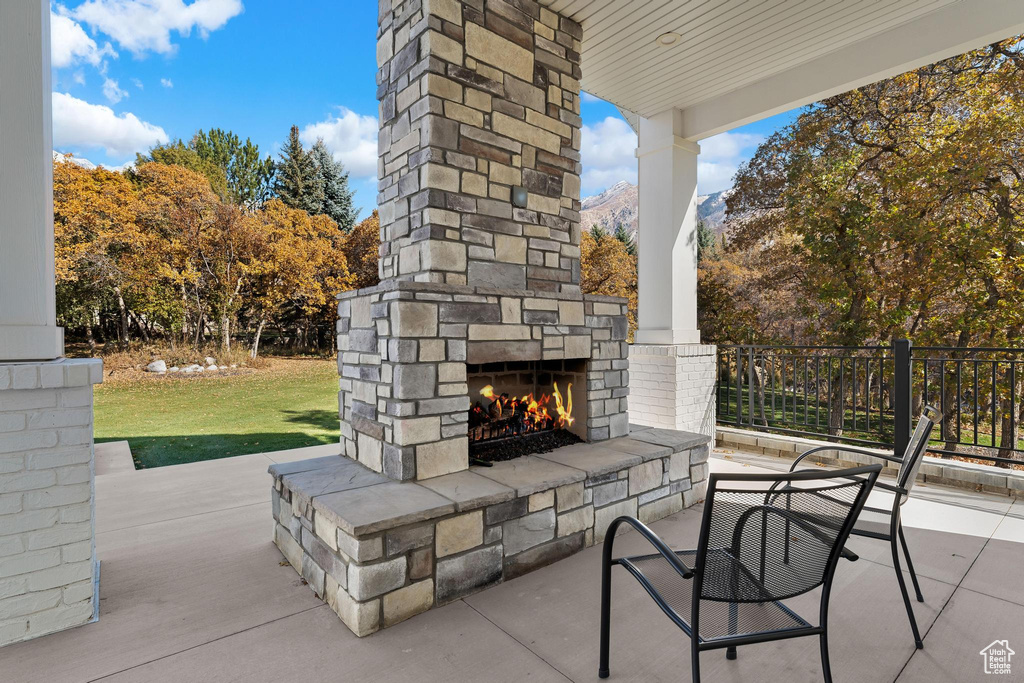 View of patio / terrace with an outdoor stone fireplace and a mountain view