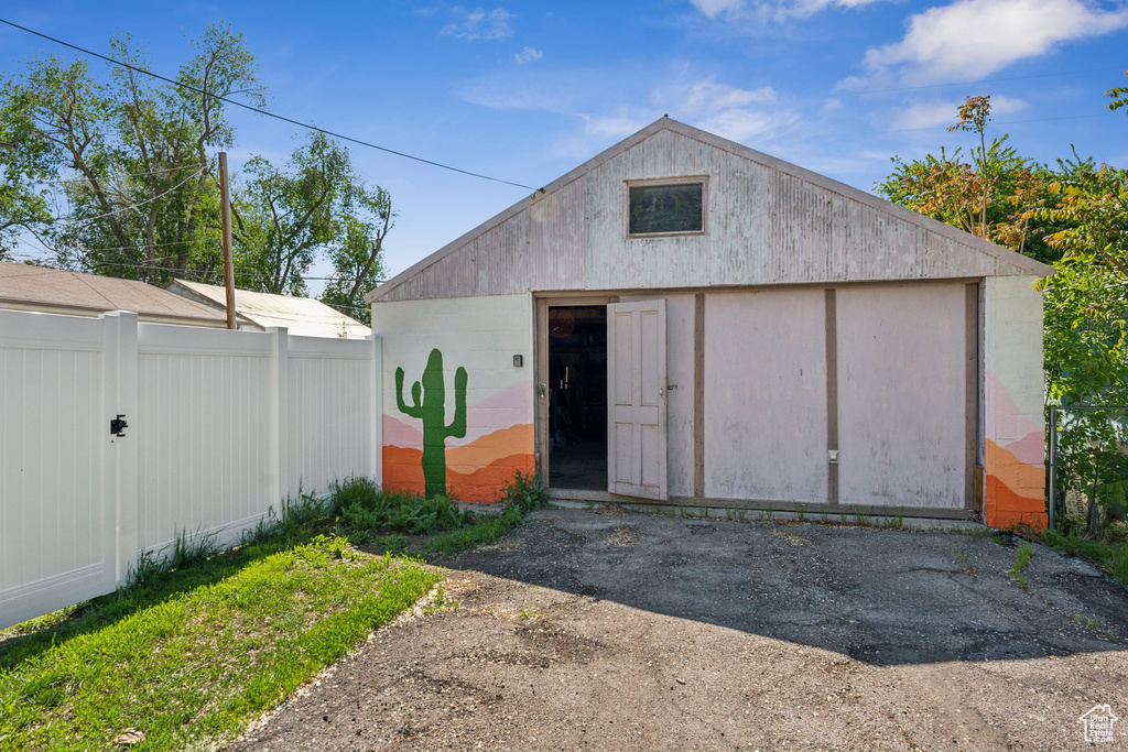 View of outbuilding featuring fence and an outbuilding