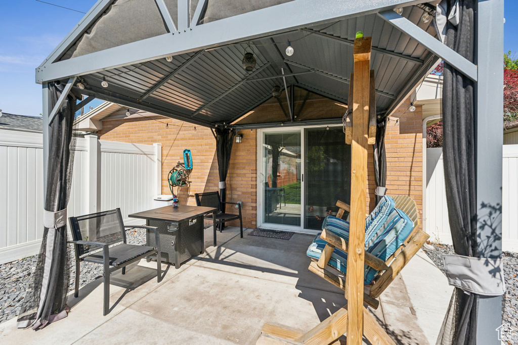 View of patio / terrace featuring a gazebo, fence, and outdoor dining space
