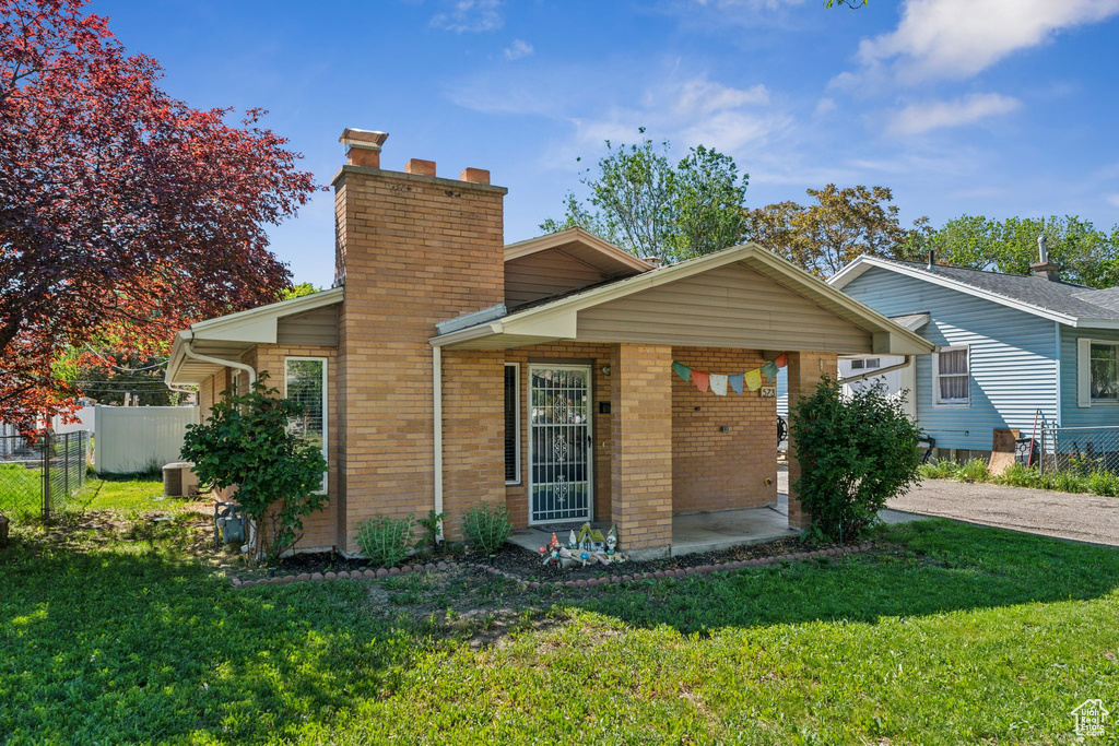 View of front facade featuring brick siding and a chimney