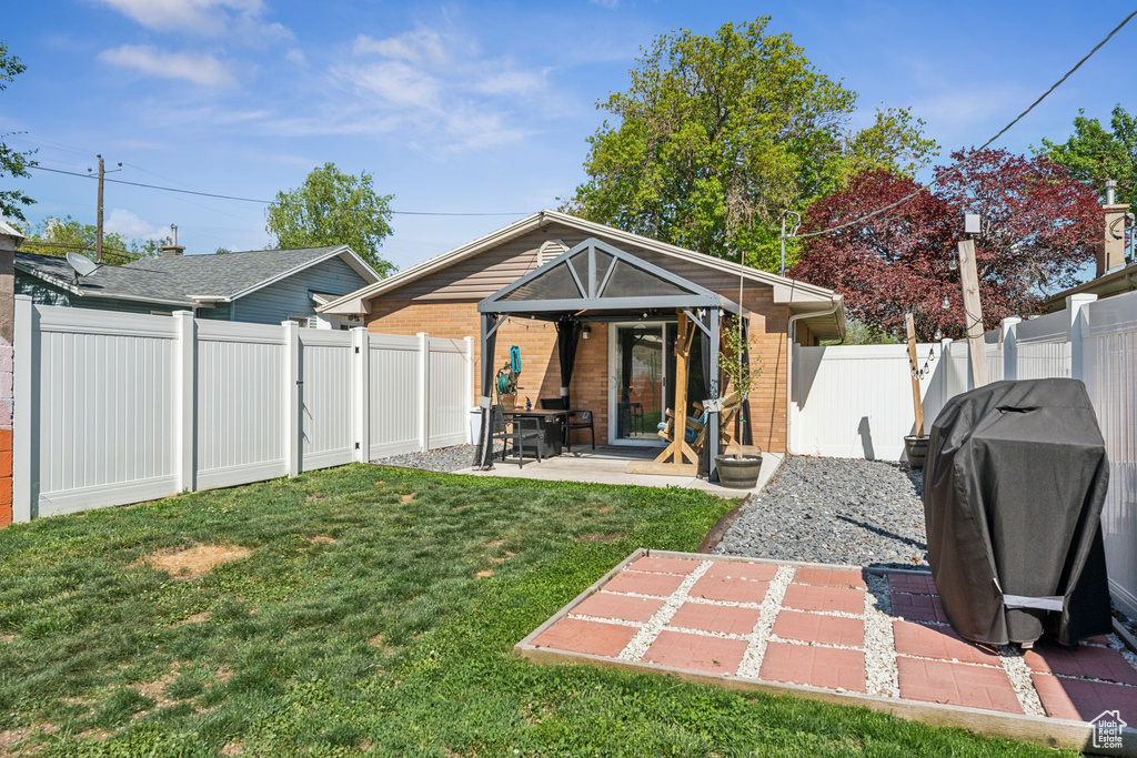 Back of property with brick siding and a patio