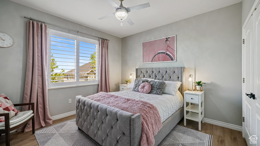 Bedroom featuring wood finished floors, baseboards, and a ceiling fan