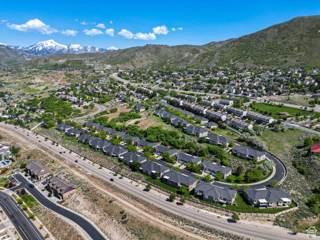 Aerial view of property and surrounding area with a mountainous background and nearby suburban area