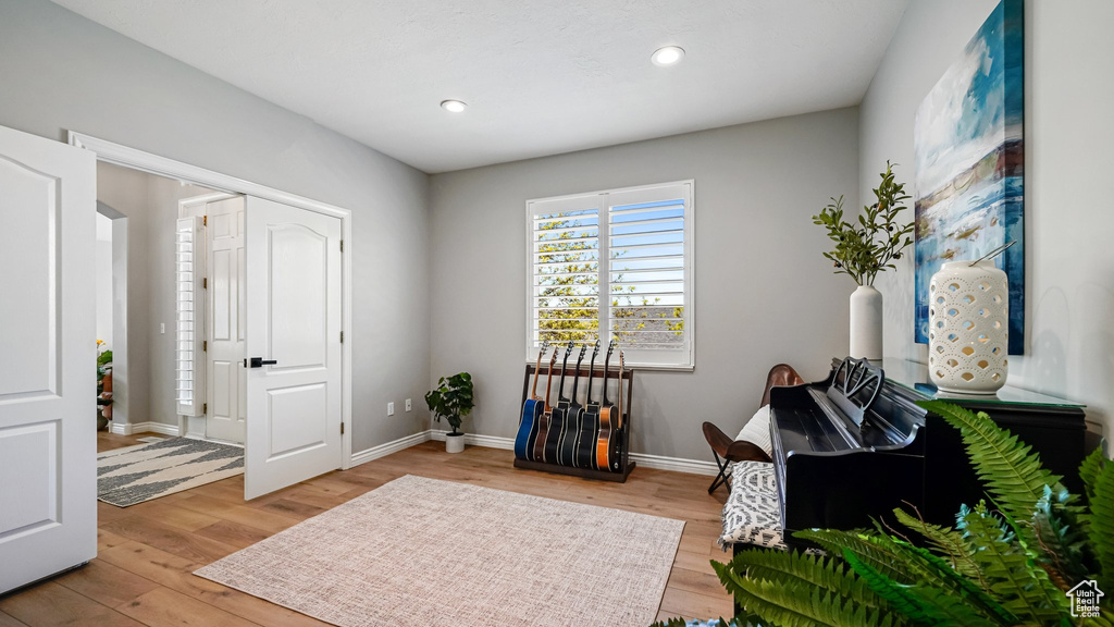 Living area featuring light wood-style floors, baseboards, and recessed lighting