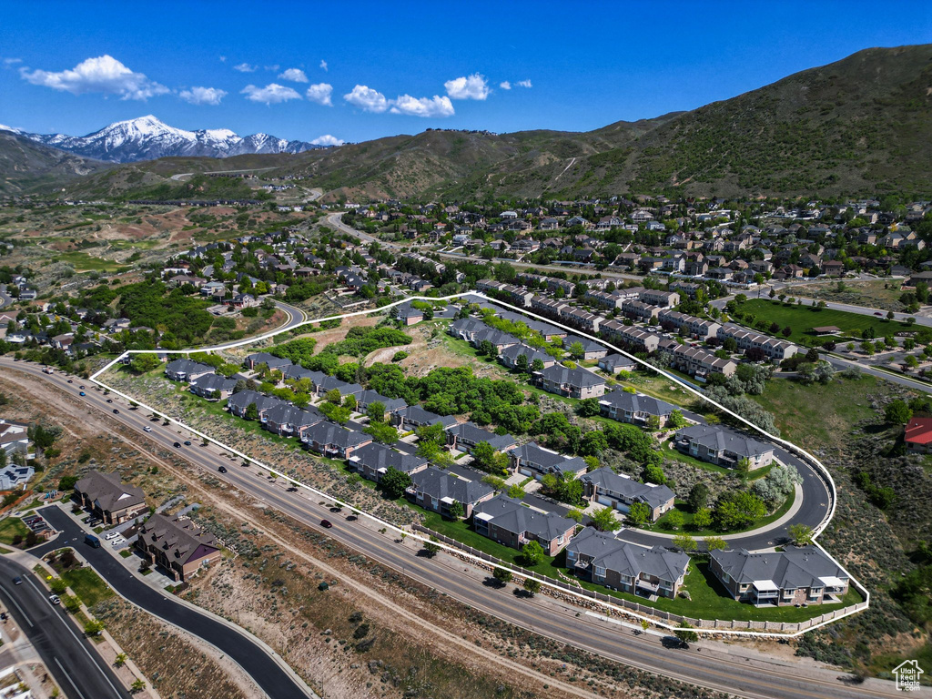 Aerial view of property and surrounding area featuring a mountain backdrop and nearby suburban area