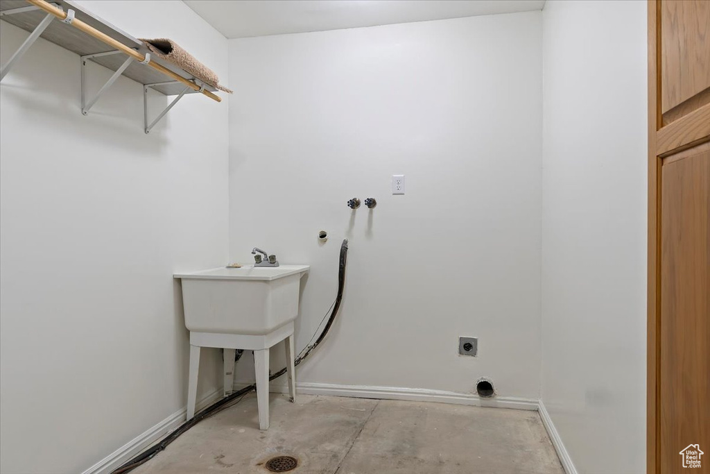 Washroom with electric dryer hookup, hookup for a washing machine, and baseboards