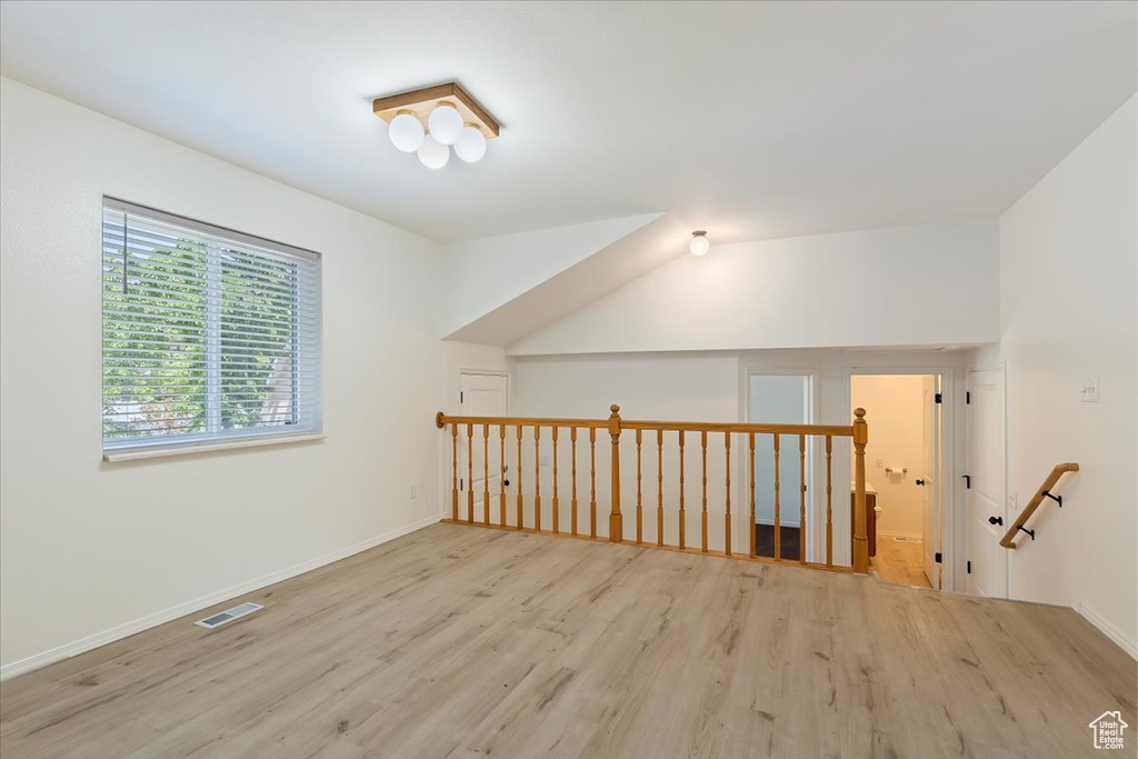 Bonus room featuring wood finished floors, baseboards, and vaulted ceiling
