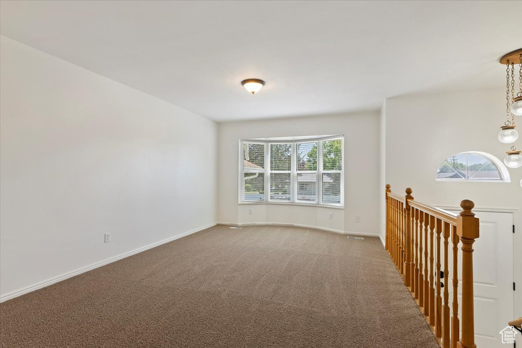Carpeted spare room with healthy amount of natural light and baseboards