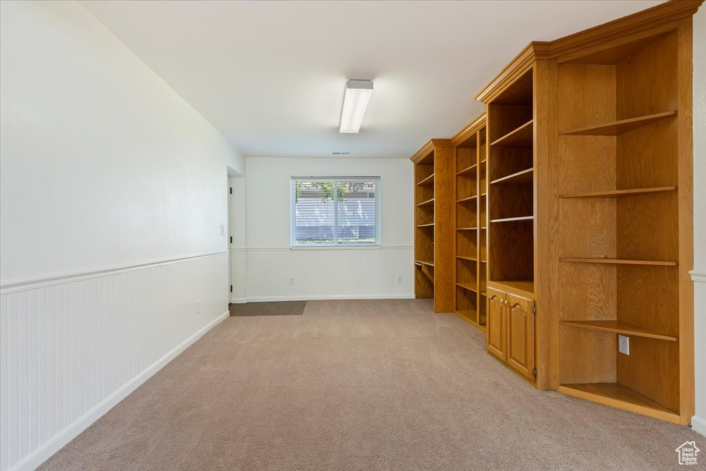 Unfurnished living room with light colored carpet and wainscoting
