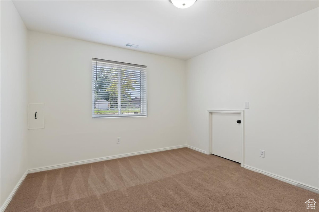 Carpeted spare room with baseboards