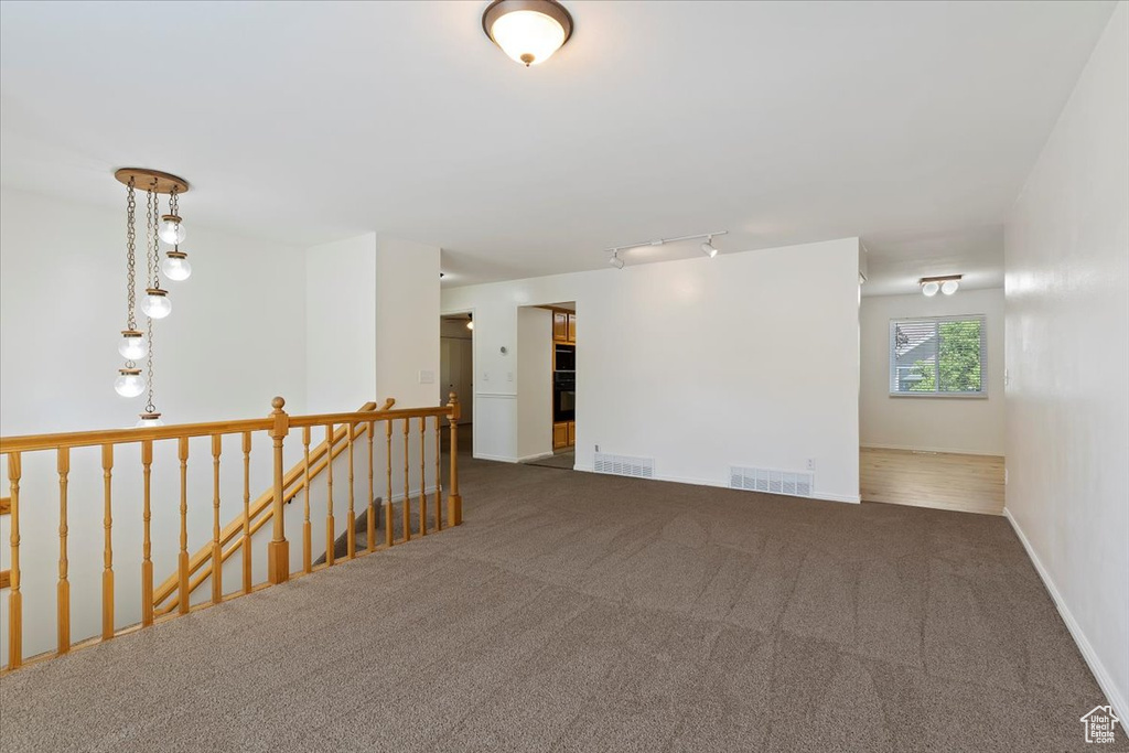 Carpeted empty room with track lighting