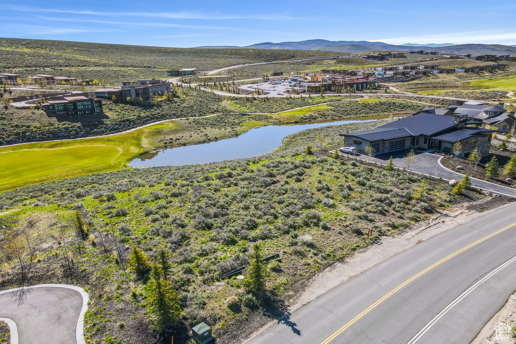 Aerial view of residential area featuring a water and mountain view and a golf course