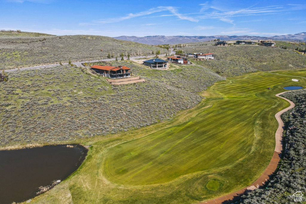 Aerial view of property's location featuring a water and mountain view and a golf course