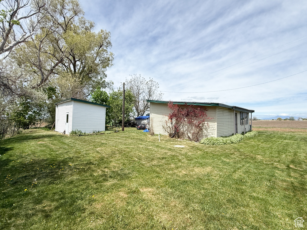 View of green lawn with an outdoor structure and a shed