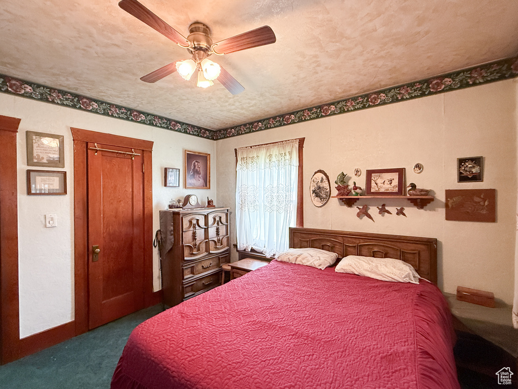 Bedroom featuring dark carpet and a ceiling fan