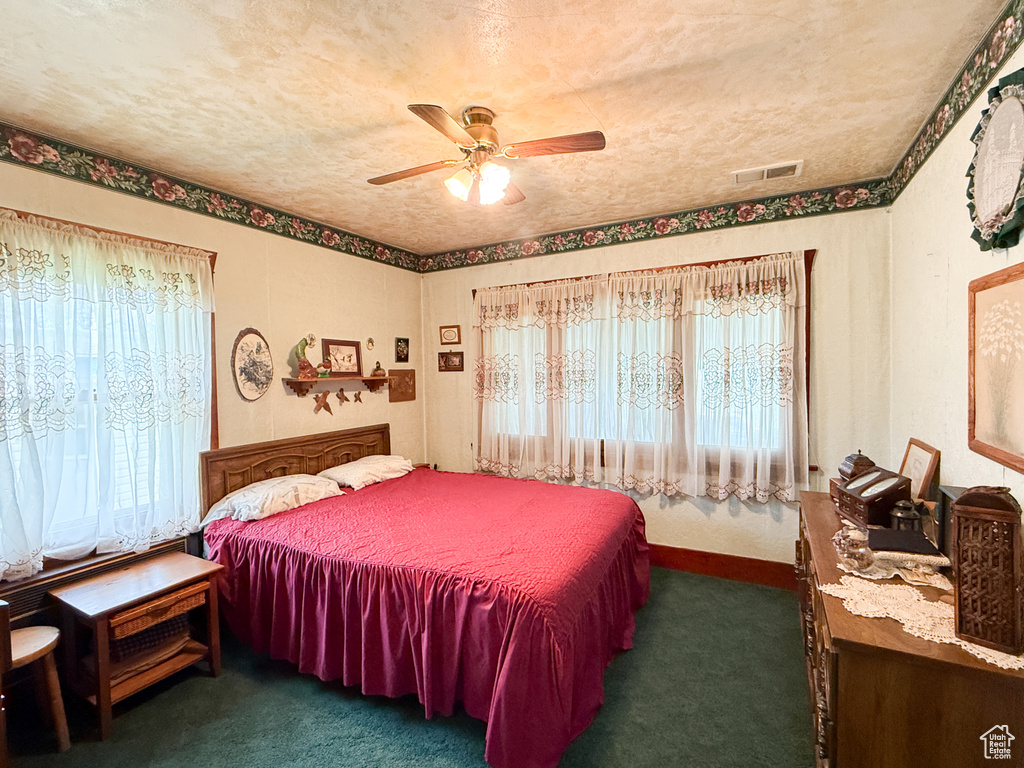 Bedroom featuring multiple windows, carpet flooring, and a ceiling fan