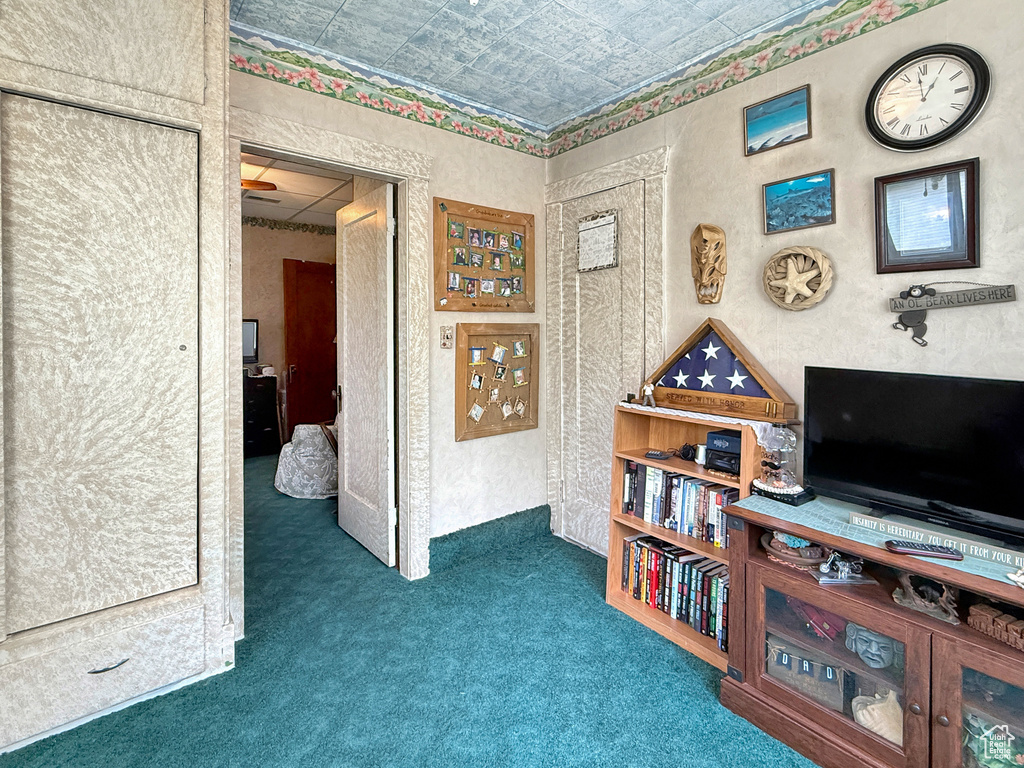 Corridor featuring an ornate ceiling, carpet floors, and a textured wall