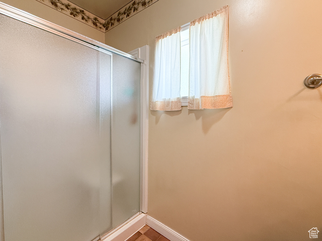 Full bathroom with a stall shower and baseboards