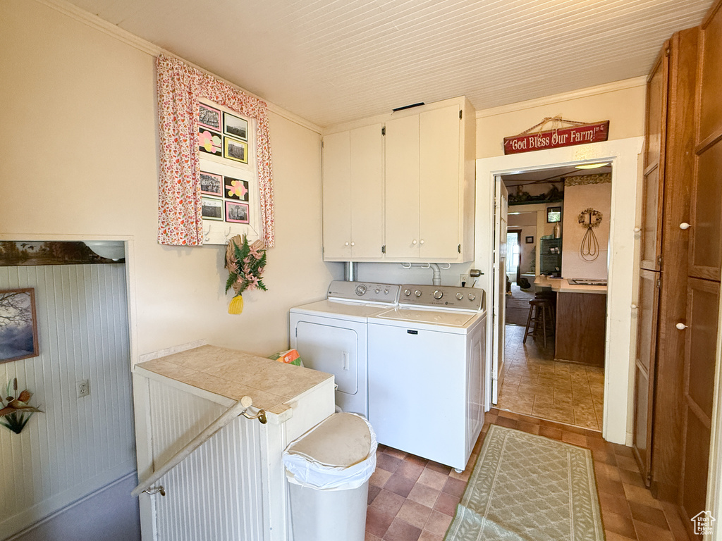 Washroom featuring independent washer and dryer and cabinet space