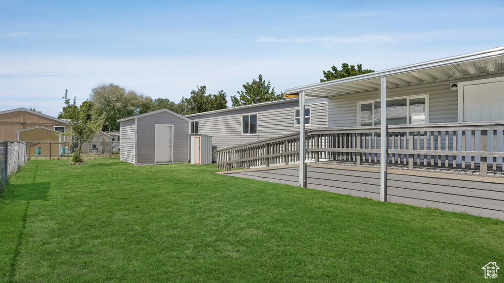 View of yard with a storage shed, an outdoor structure, and a wooden deck
