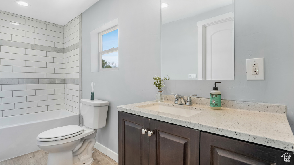 Full bath with wood finished floors, toilet, vanity, baseboards, and recessed lighting