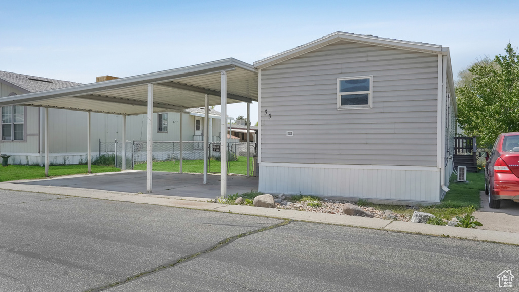 View of parking / parking lot with a carport and driveway